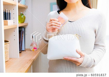 化粧品をポーチに入れる、取り出す女性 60591837