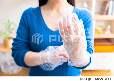 ビニール手袋をはめる女性の写真素材