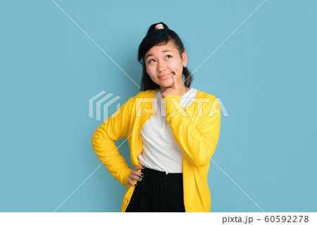 Asian teenager's portrait isolated on blue studio background 60592278