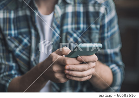 Man holding a smartphone in a blue case. Man holding a smartphone in a blue case. 60592610