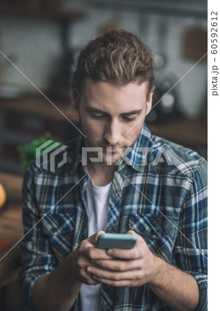 Concentrated young man texting about his business Concentrated young man texting about his business 60592612