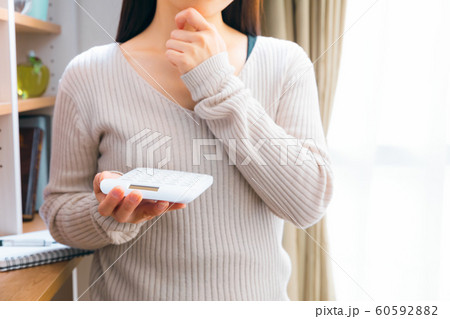 電卓を持ち考える女性 電卓を持ち考える女性 60592882