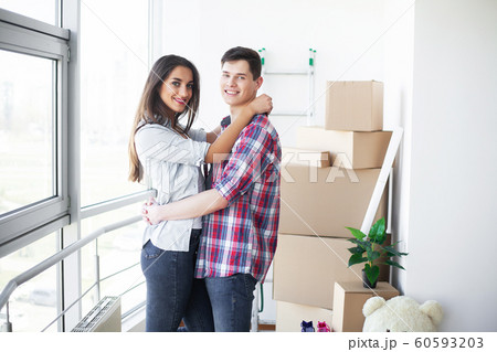 New Home. Funny young couple enjoy and celebrating moving to new home. Happy couple at empty room of new home 60593203