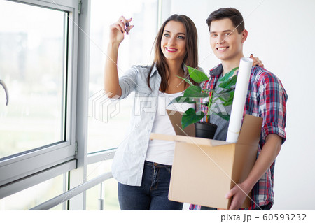 New Home. Funny young couple enjoy and celebrating moving to new home. Happy couple at empty room of new home 60593232