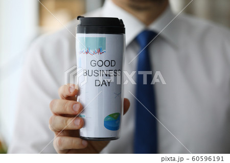 Man hold in hand thermal flask with hot beverage closeup Man hold in hand thermal flask with hot beverage closeup 60596191