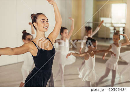 young female ballerina show right pose to kids in studio young female ballerina show right pose to kids in studio 60596484