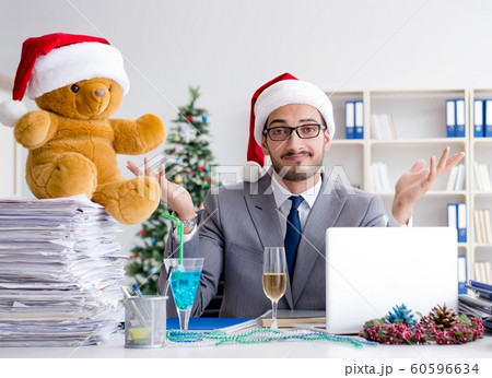 Young businessman celebrating christmas in the office Young businessman celebrating christmas in the office 60596634