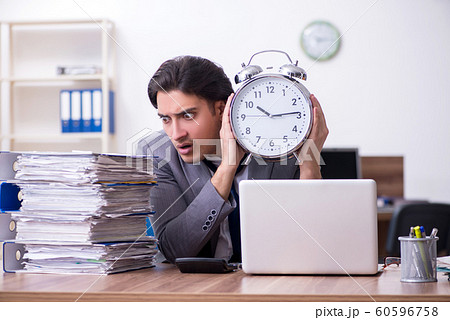 Young male employee unhappy with excessive work Young male employee unhappy with excessive work 60596758