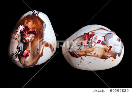 Caramel, coffee and chocolate stone desserts with almonds and rose petals top down on black background Caramel, coffee and chocolate stone desserts with almonds and rose petals top down on black background 60596820