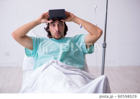 Young man staying in hospital in transfusion concept Young man staying in hospital in transfusion concept 60598029