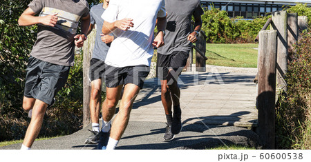 Group of boys crossing wood bridge running 60600538