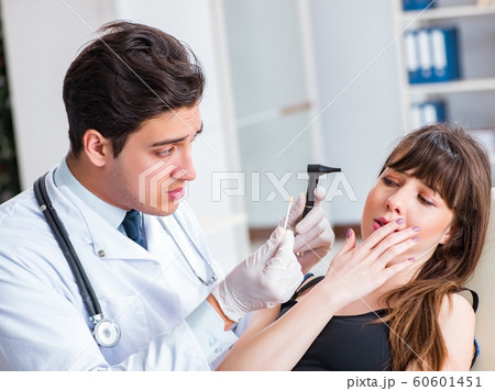 Doctor checking patients ear during medical examination 60601451