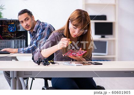 Two technicians working at computer warranty center 60601905
