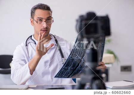Young male doctor radiologist recording video for his blog 60602660