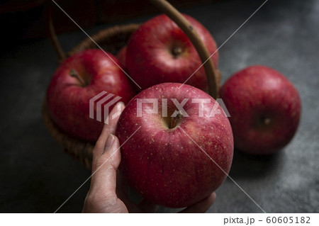 林檎を持つ手と、籠入りの林檎 林檎を持つ手と、籠入りの林檎 60605182