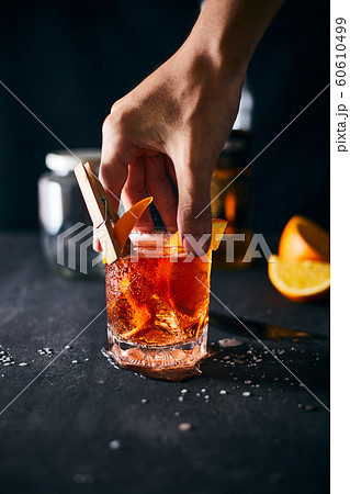 Alcoholic cocktail with orange peel and ice.. 60610499