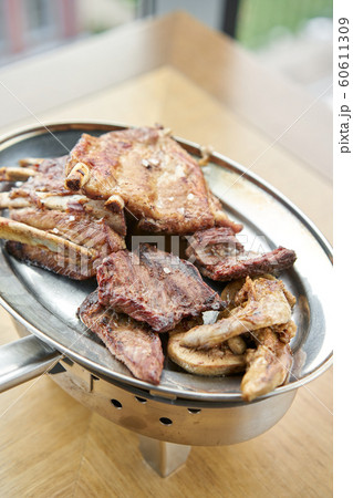 Various grilled meat set heated on coals. Barbecue restaurant menu. Many different food on the table. Dinner party or Banquet 60611309