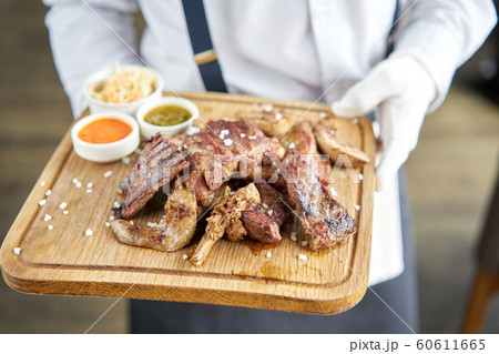 Various grilled meat set with Pickled cabbage and two sauces. Serving on a wooden Board. Barbecue restaurant menu, a series of photos of different meats. 60611665
