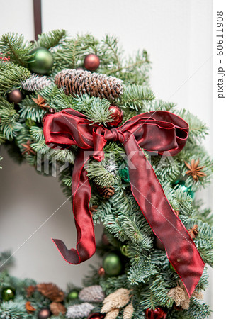 Closeup details of Beautiful Christmas wreath of fresh spruce on the white door. Entrance to the house. Christmas mood. Xmas tree. 60611908