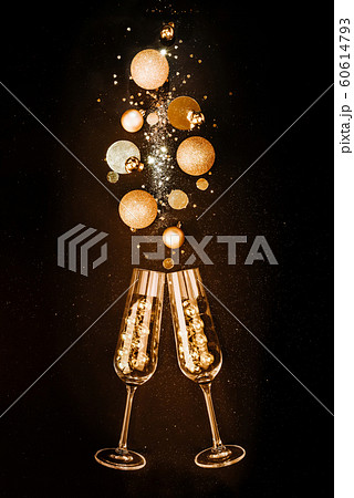 Christmas composition. Glasses with champagne wine from gold festive decorations on a black background with glitters. The concept of a party and a festive feast Christmas composition. Glasses with champagne wine from gold festive decorations on a black background with glitters. The concept of a party and a festive feast 60614793