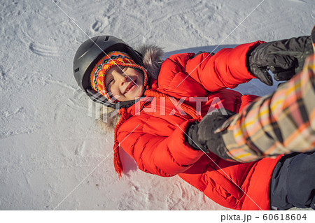 Mother teaches son snowboarding. Activities for children in winter. Children's winter sport 60618604