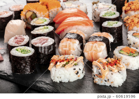 Large sushi set, close-up on a black background. An assortment of various maki, nigiri and rolls 60619596