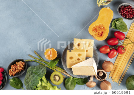 Vegetarian food background. An overhead shot of fruits, vegetables, cheese, mushrooms, and pasta, nuts and legumes, with a place for text 60619691