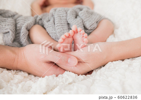 両親の手に包まれた新生児 60622836