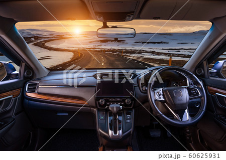 Looking through a car windshield with sunset and road in winter. Travel in car. 60625931