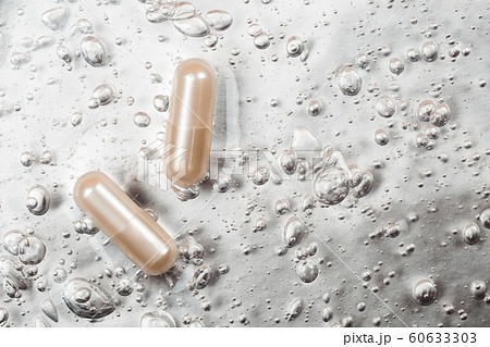 Beauty capsule on backdrop with cosmetic oxygen bubbles 60633303