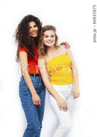 young pretty teenage girls friends with blond and brunette curly hairs posing cheerful isolated on white background, lifestyle people concept 60635975
