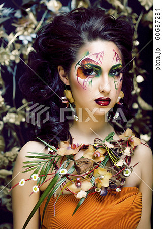 beauty woman with face art and jewelry from flowers orchids close up, creative makeup floral pattern background 60637234