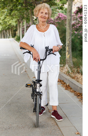 Senior woman resting near bike Senior woman resting near bike 60641323