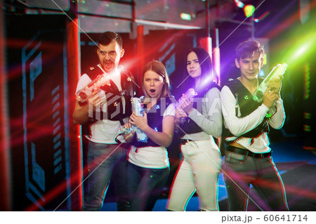 Young people in colorful beams on lasertag arena Young people in colorful beams on lasertag arena 60641714