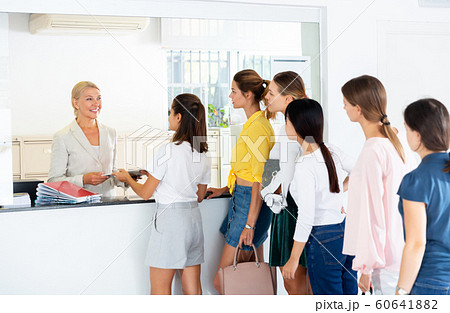 Students standing in line at reception desk Students standing in line at reception desk 60641882