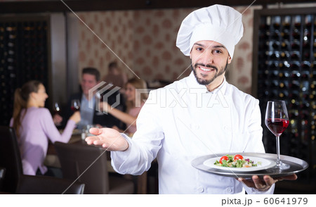 Young chef with serving tray meeting guests Young chef with serving tray meeting guests 60641979