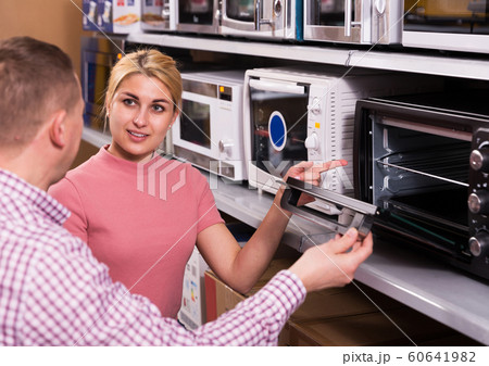 couple choosing new microwave for kitchen 60641982