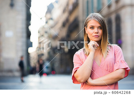Close-up of young thoughtful woman in dress standing in historical center Close-up of young thoughtful woman in dress standing in historical center 60642268