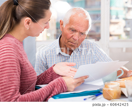 Sad young woman and father with financial documents at home Sad young woman and father with financial documents at home 60642425
