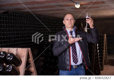 Winemaker proposing degustation of red wine 60642827