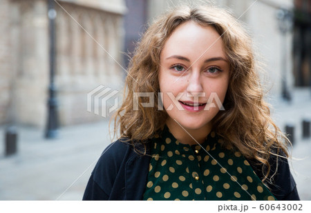 Smiling young woman standing at the street among architecture in Barcelona 60643002