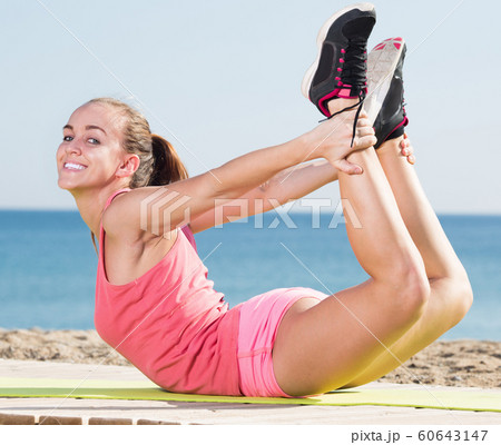 Happy girl in sportswear training at sea beach Happy girl in sportswear training at sea beach 60643147