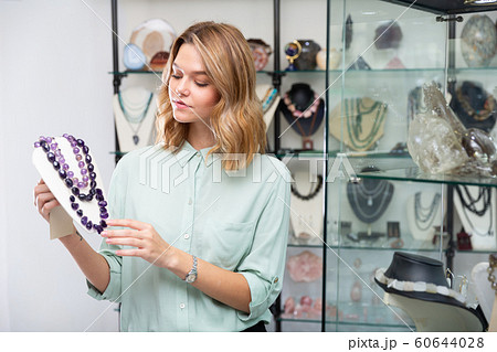 Woman demonstrating amethyst stone necklace Woman demonstrating amethyst stone necklace 60644028