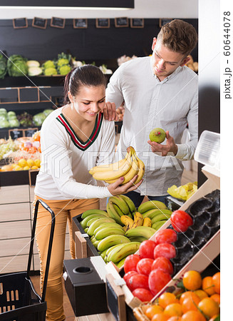 Buyers choosing various fruits in grocery store 60644078