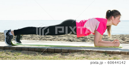 Woman exercising yoga poses on beach Woman exercising yoga poses on beach 60644142