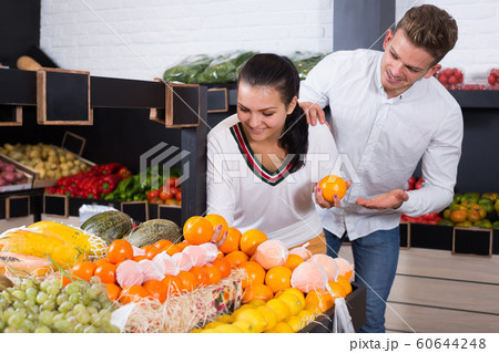 Happy loving couple deciding on fruits in shop 60644248