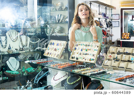 Girl trying on natural stone necklace 60644389