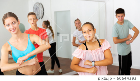 Teenagers exercising with coach in choreography class Teenagers exercising with coach in choreography class 60644393
