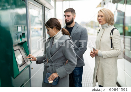 Passengers buying ticket at ticket vending machine Passengers buying ticket at ticket vending machine 60644591