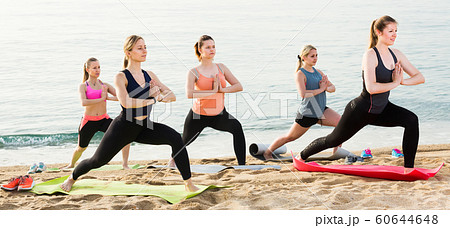 attractive females exercising yoga poses on sunny beach attractive females exercising yoga poses on sunny beach 60644648